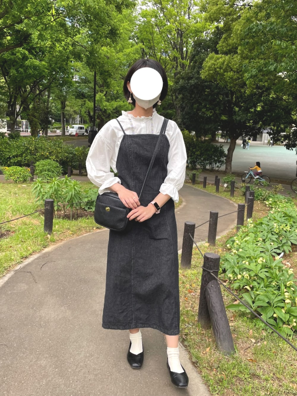 ブラック系のショルダーバッグ、ブラック系のパンプス、ホワイト系のシャツ/ブラウスを着用したレディースの春コーディネートの2枚目の写真