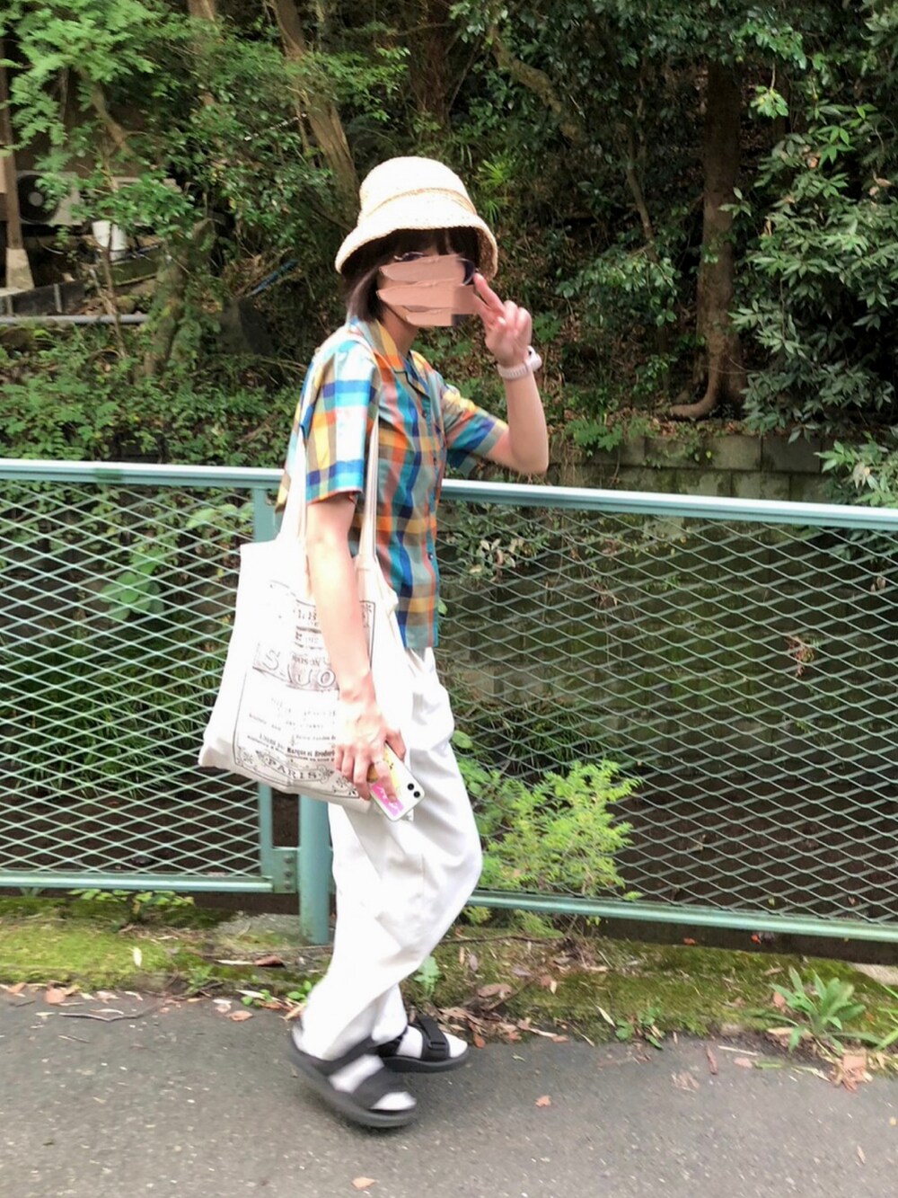 ホワイト系のトートバッグ、ホワイト系のパンツ、グレー系のサンダルを着用したレディースの秋コーディネートの2枚目の写真