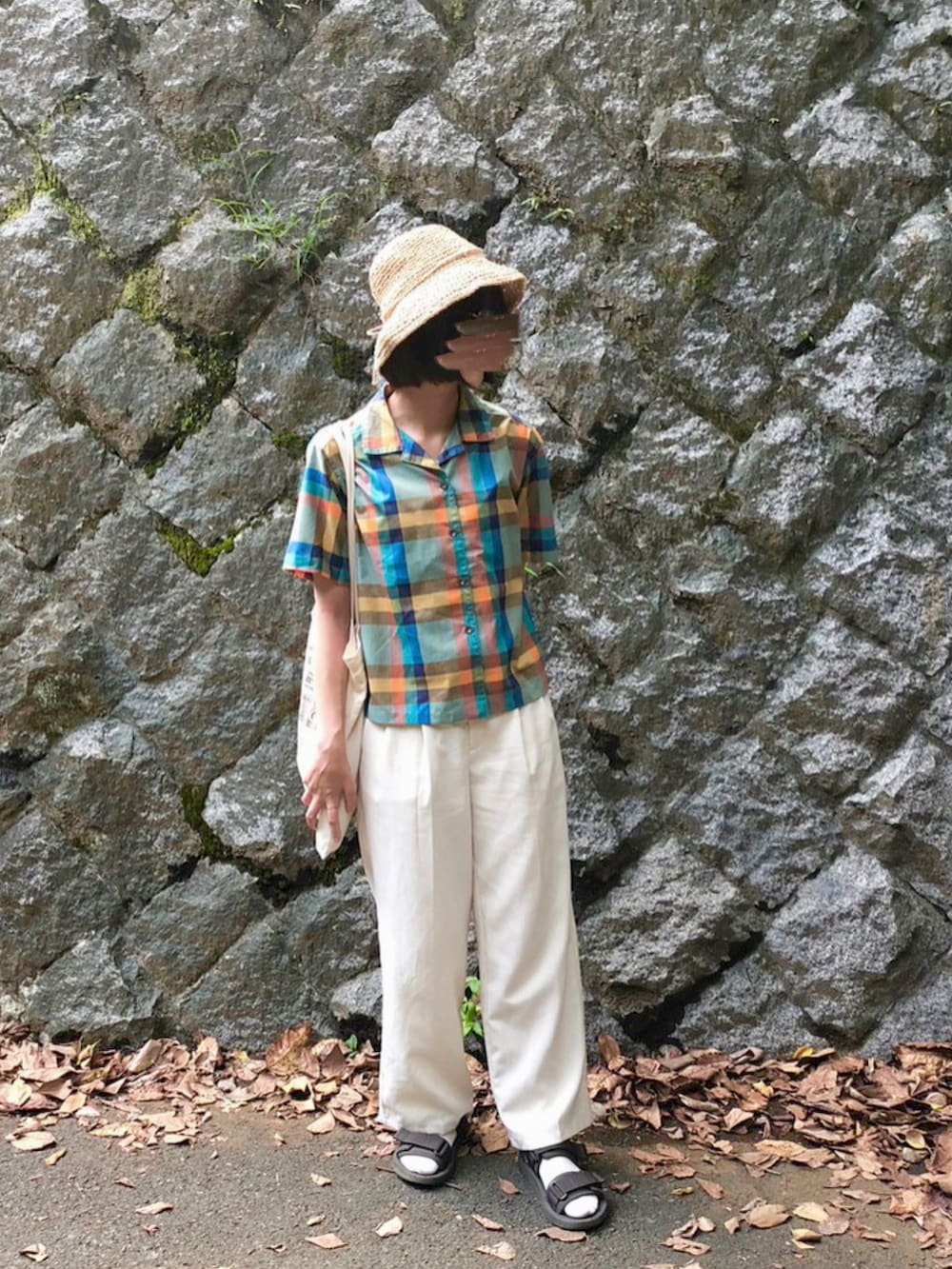 ホワイト系のトートバッグ、ホワイト系のパンツ、グレー系のサンダルを着用したレディースの秋コーディネートの3枚目の写真