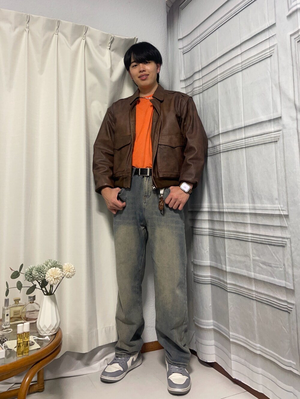 グレー系のスニーカー、ブルー系のデニムパンツ、シルバー系のネックレスを着用したメンズの春コーディネートの2枚目の写真