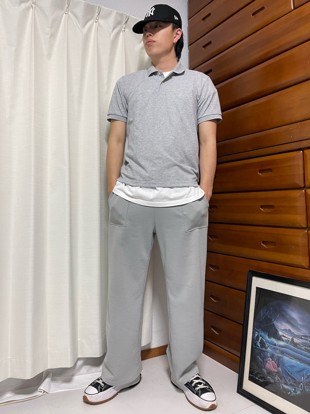 グレー系のポロシャツ、ホワイト系のTシャツ/カットソー、グレー系のスウェットパンツを着用したメンズの春コーディネートの3枚目の写真