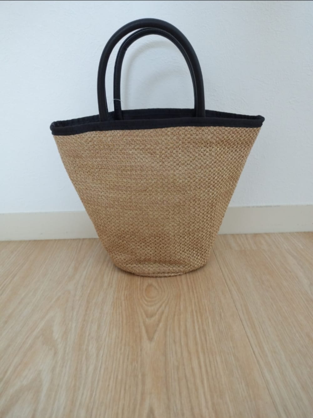 ベージュ系のかごバッグを着用したレディースの春コーディネートの2枚目の写真