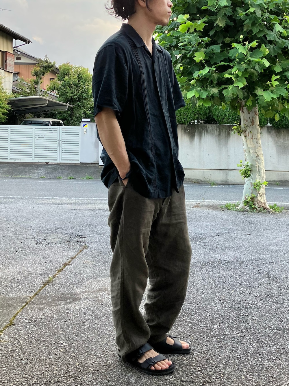 ブラウン系のパンツ、ブラック系のサンダル、シルバー系のデジタル腕時計を着用したメンズの夏コーディネートの2枚目の写真