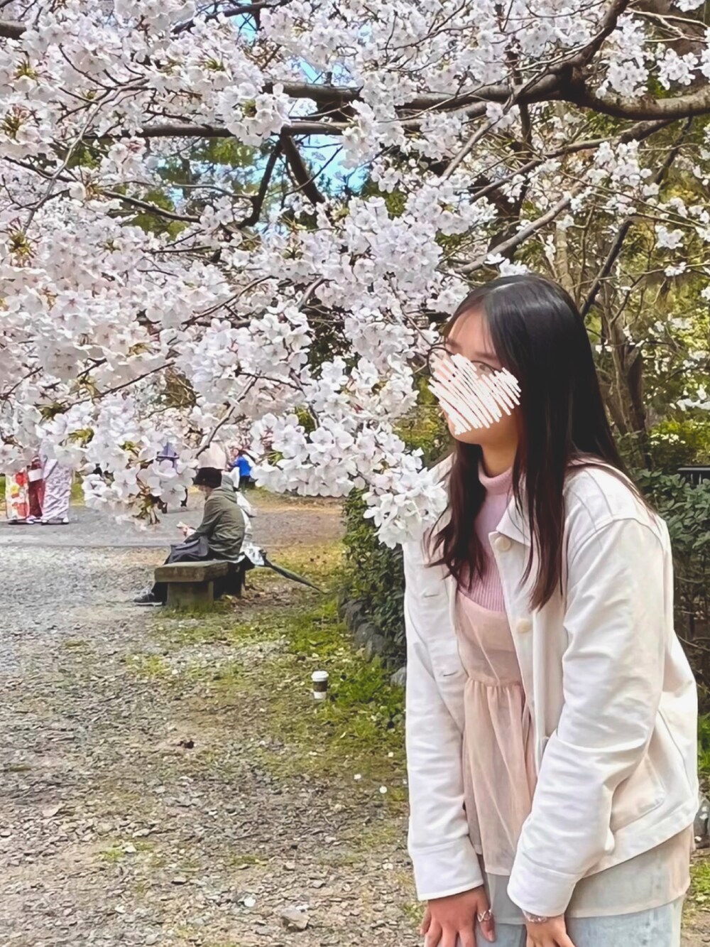 ピンク系のニット/セーター、オレンジ系のキャミソール、ブルー系のデニムパンツを着用したレディースの春コーディネートの2枚目の写真