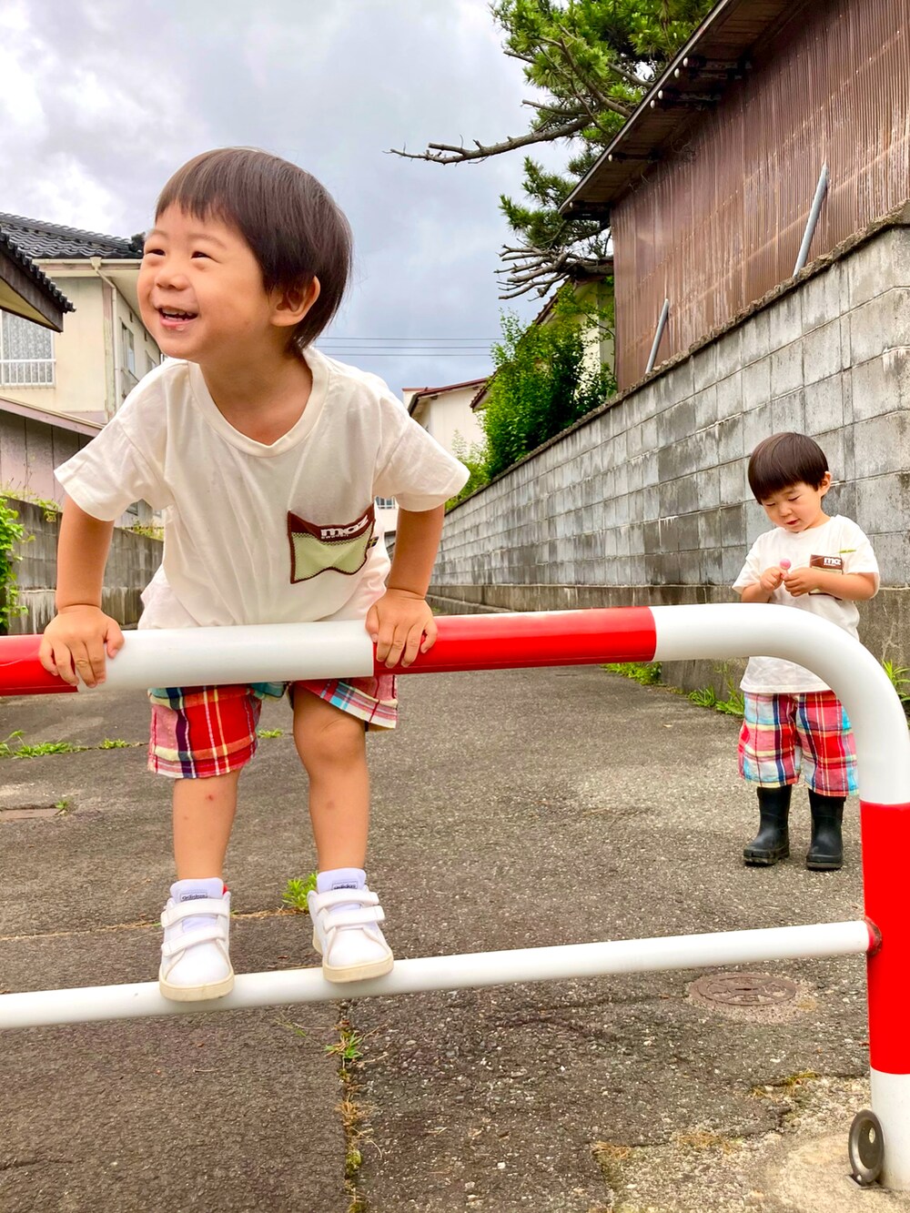 ベージュ系のTシャツ/カットソー、レッド系のパンツ、ホワイト系のスニーカーを着用したキッズの夏コーディネートの2枚目の写真