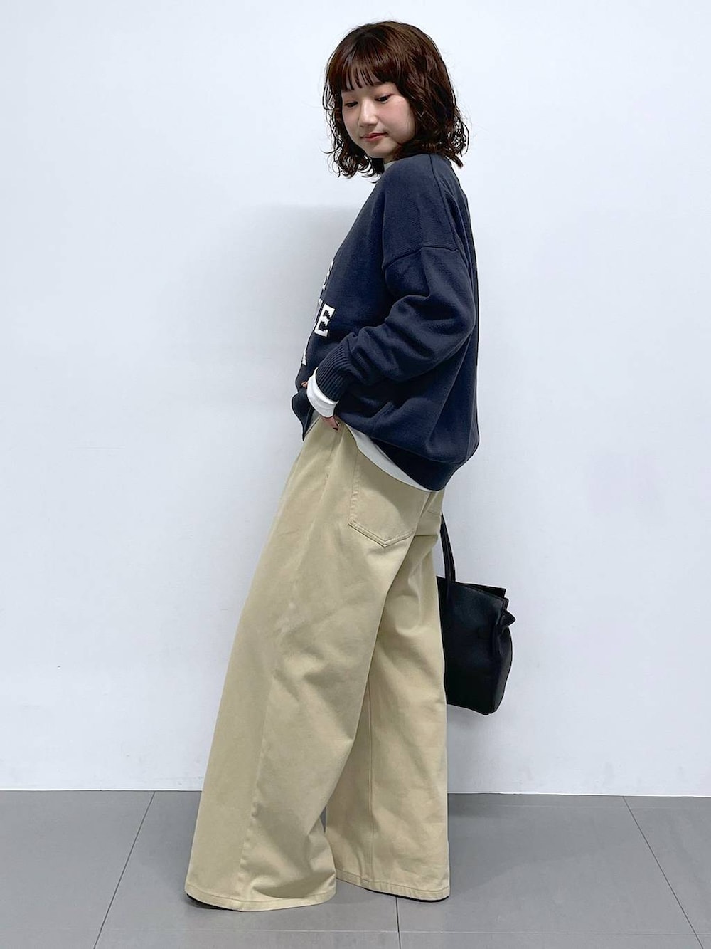 グレー系のニット/セーター、ベージュ系のデニムパンツを着用したレディースの冬コーディネートの2枚目の写真