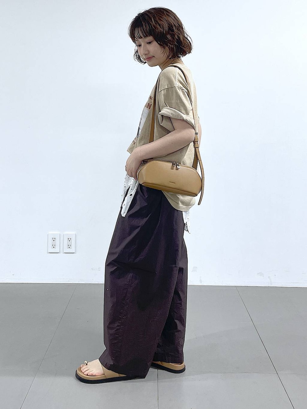 ブラウン系のその他パンツ、ベージュ系のTシャツ/カットソー、ブラウン系のショルダーバッグを着用したレディースの春コーディネートの2枚目の写真