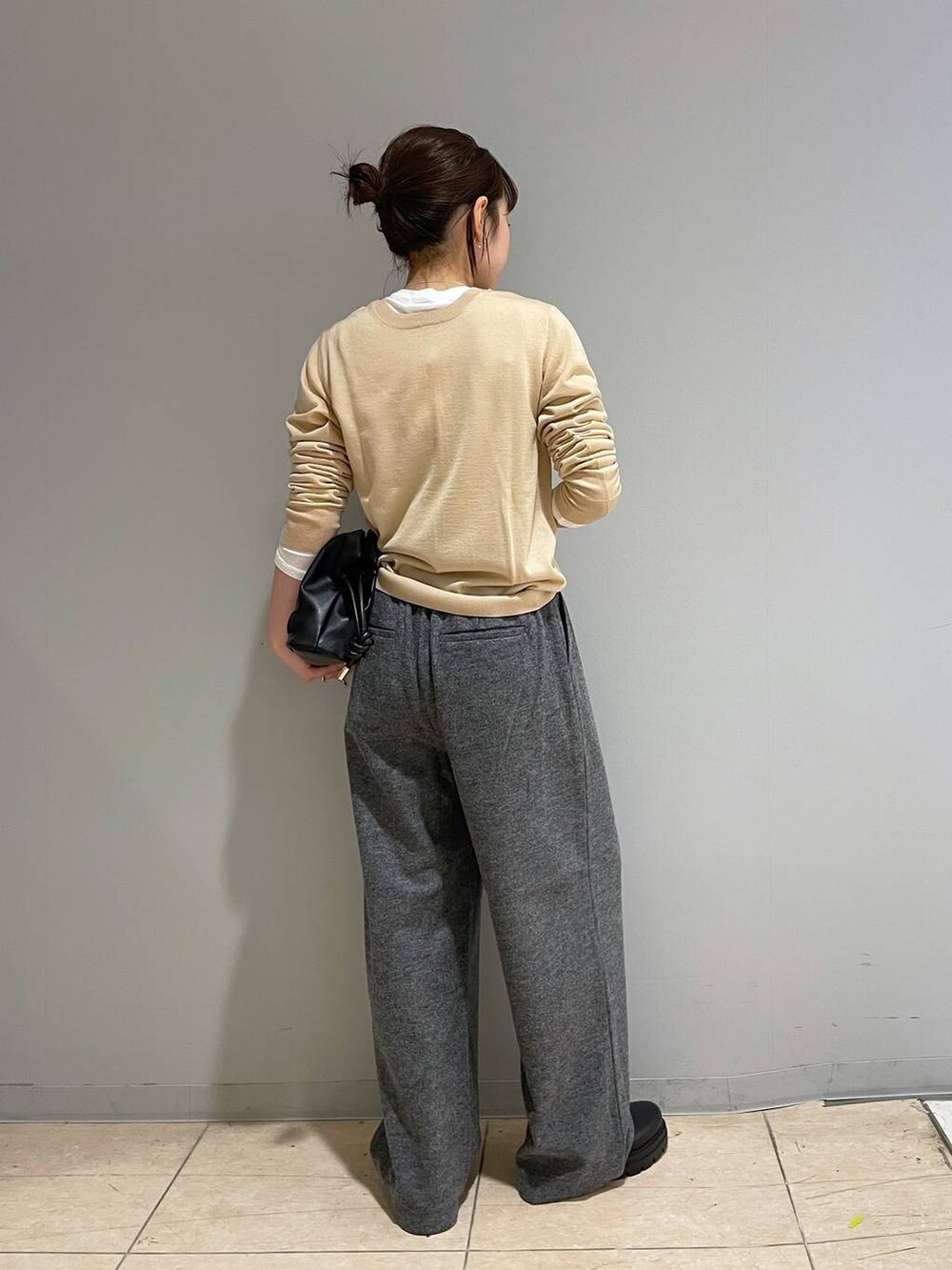 ブラック系のブーツ、ベージュ系のカーディガン/ボレロ、グレー系のスラックスを着用したレディースの冬コーディネートの3枚目の写真