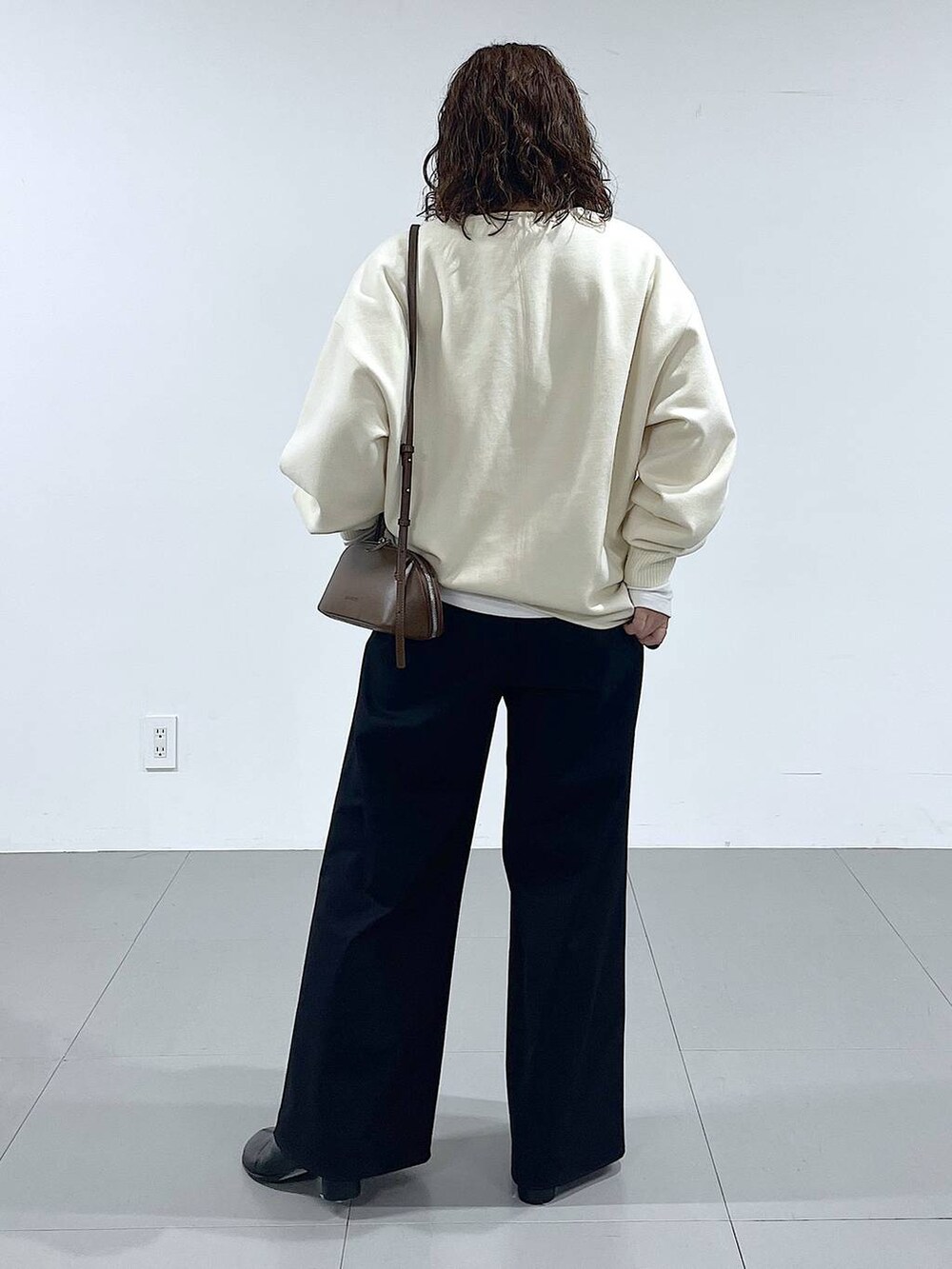 ブラウン系のショルダーバッグ、ブラック系のブーツ、ホワイト系のTシャツ/カットソーを着用したレディースの秋コーディネートの3枚目の写真