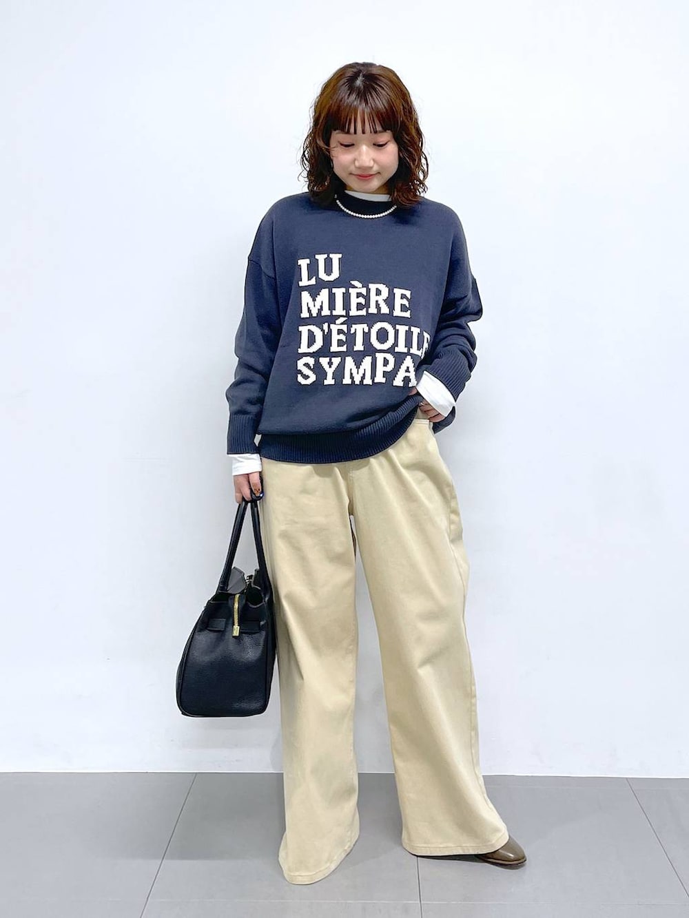 グレー系のニット/セーター、ベージュ系のデニムパンツを着用したレディースの冬コーディネートの4枚目の写真