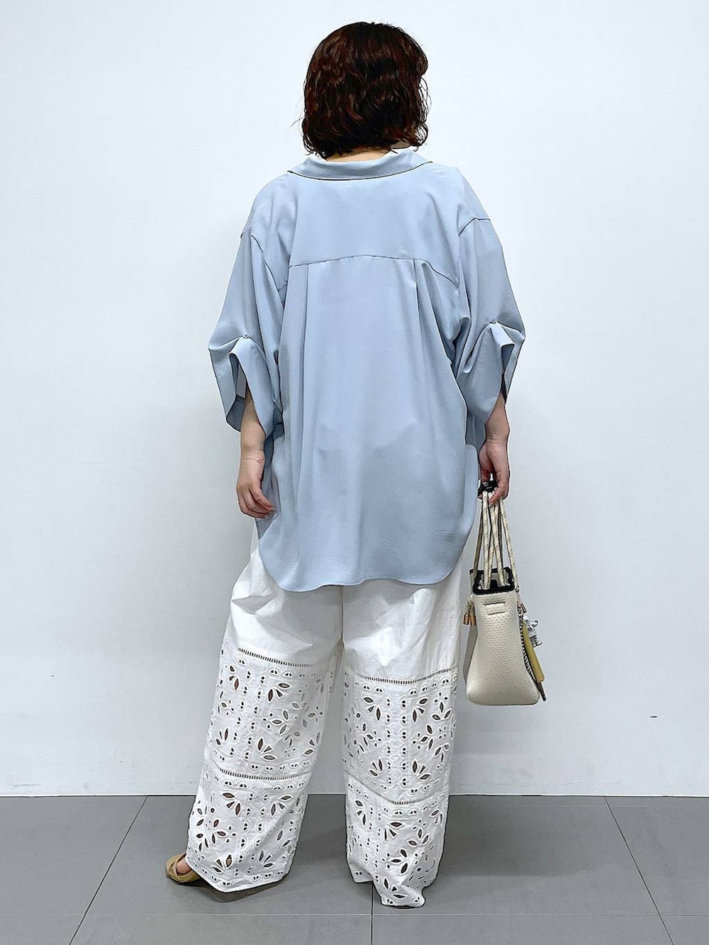 ホワイト系のその他パンツ、ブルー系のシャツ/ブラウス、ホワイト系のトートバッグを着用したレディースの冬コーディネートの3枚目の写真