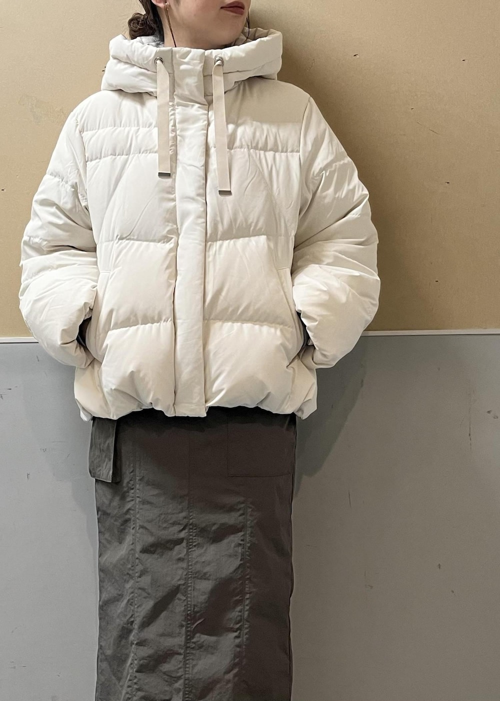 ホワイト系のダウンジャケット/コート、ブラック系のブーツ、グレー系のニット/セーターを着用したレディースの冬コーディネートの4枚目の写真