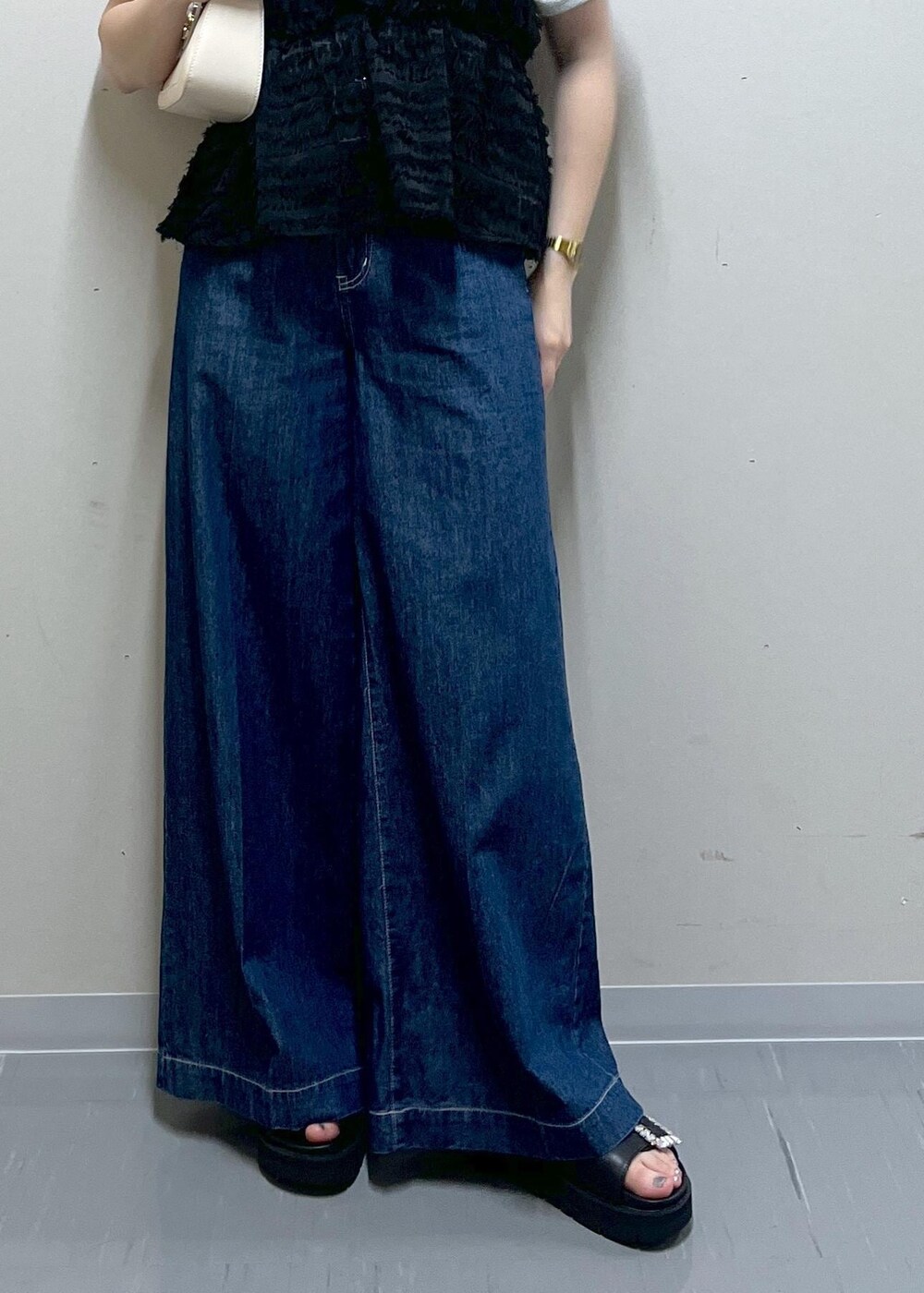 ホワイト系のハンドバッグ、ブラック系のサンダル、グレー系のTシャツ/カットソーを着用したレディースの夏コーディネートの5枚目の写真