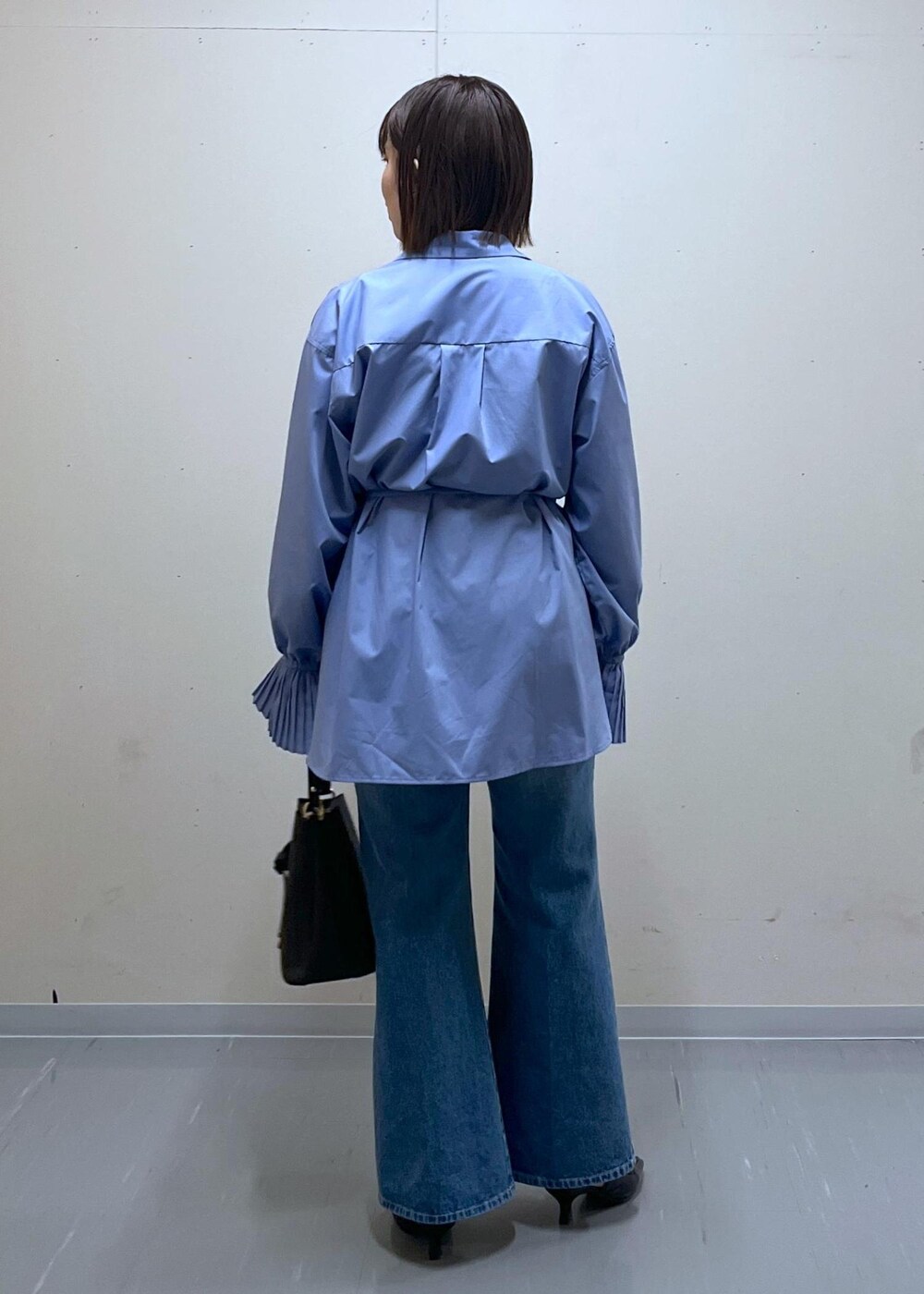 ブラック系のショルダーバッグ、ブルー系のデニムパンツ、ブルー系のシャツ/ブラウスを着用したレディースの春コーディネートの4枚目の写真