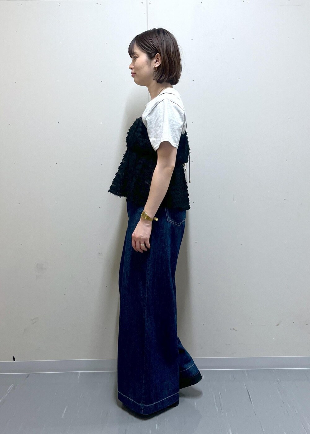 ホワイト系のハンドバッグ、ブラック系のサンダル、グレー系のTシャツ/カットソーを着用したレディースの夏コーディネートの2枚目の写真