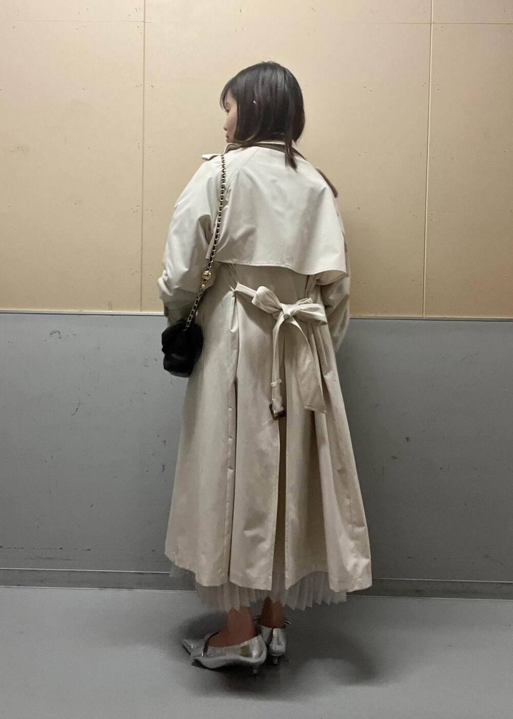 グレー系のニット/セーター、ホワイト系のトレンチコート、シルバー系のパンプスを着用したレディースの春コーディネートの2枚目の写真