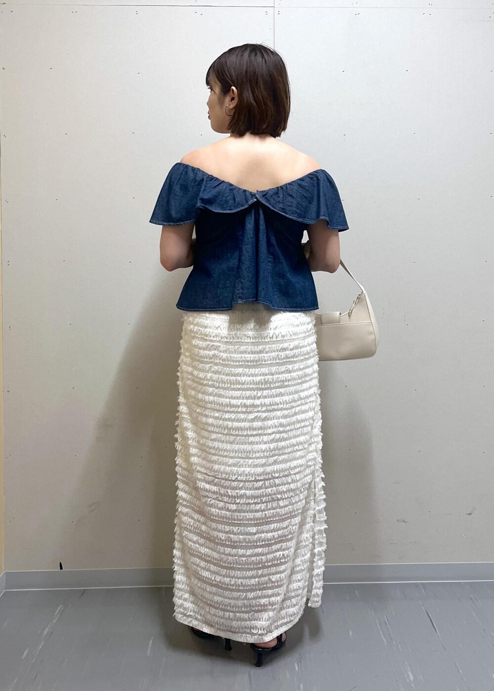 ホワイト系のハンドバッグ、ブラック系のサンダル、ブルー系のシャツ/ブラウスを着用したレディースの夏コーディネートの3枚目の写真