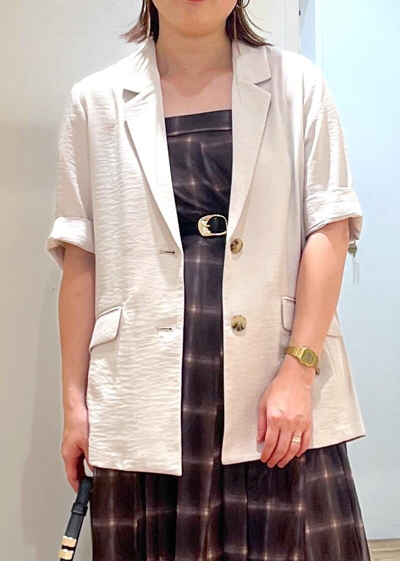 ブラック系のハンドバッグ、ブラック系のサンダル、ホワイト系のテーラードジャケットを着用したレディースの夏コーディネートの6枚目の写真