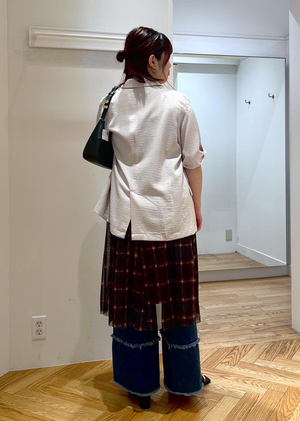 ブラック系のハンドバッグ、ブラック系のサンダル、ホワイト系のテーラードジャケットを着用したレディースの夏コーディネートの5枚目の写真