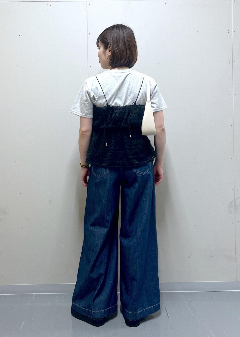 ホワイト系のハンドバッグ、ブラック系のサンダル、グレー系のTシャツ/カットソーを着用したレディースの夏コーディネートの3枚目の写真