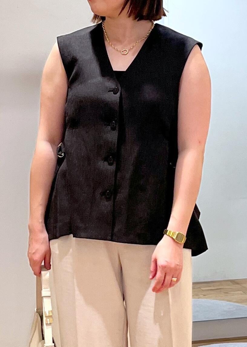 ホワイト系のハンドバッグ、ホワイト系のサンダル、ホワイト系のスラックスを着用したレディースの夏コーディネートの5枚目の写真