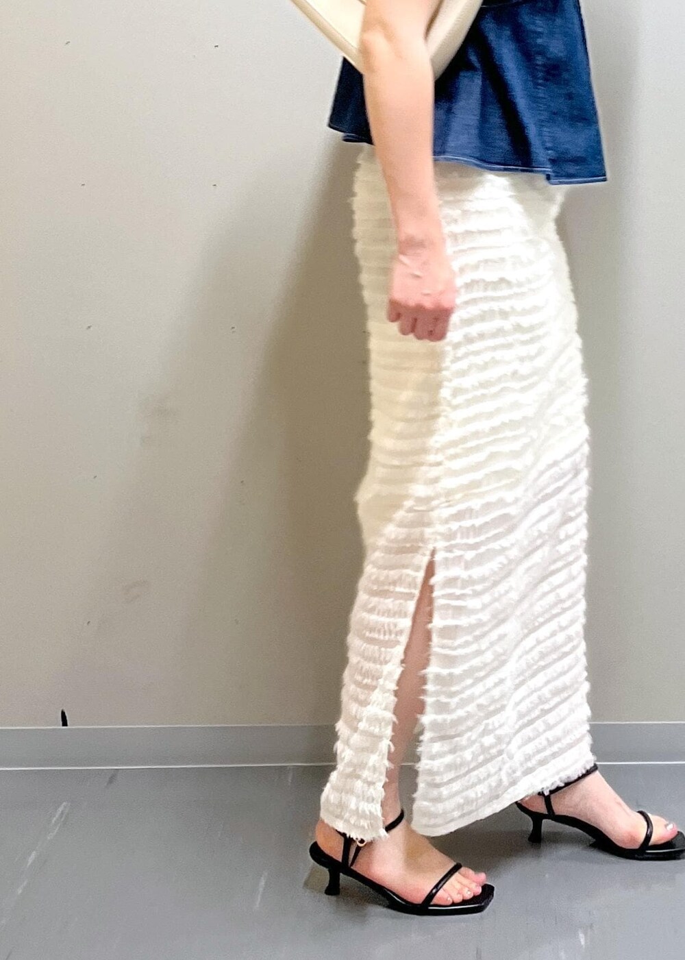 ホワイト系のハンドバッグ、ブラック系のサンダル、ブルー系のシャツ/ブラウスを着用したレディースの夏コーディネートの5枚目の写真