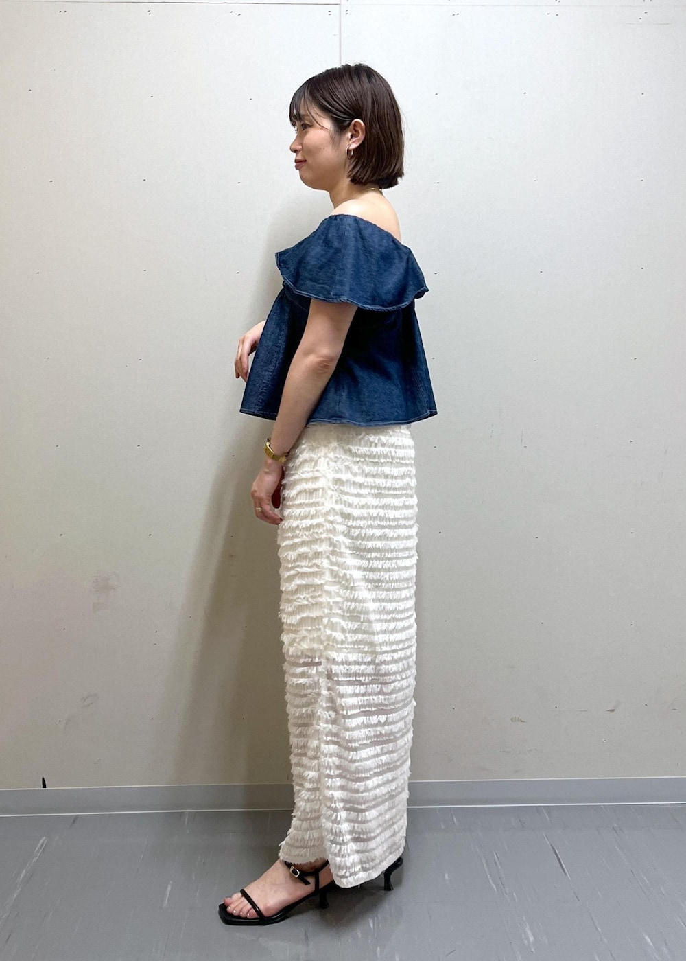 ホワイト系のハンドバッグ、ブラック系のサンダル、ブルー系のシャツ/ブラウスを着用したレディースの夏コーディネートの2枚目の写真