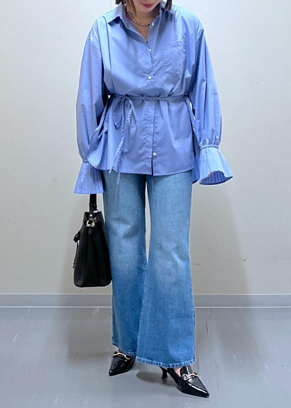ブラック系のショルダーバッグ、ブルー系のデニムパンツ、ブルー系のシャツ/ブラウスを着用したレディースの春コーディネートの2枚目の写真