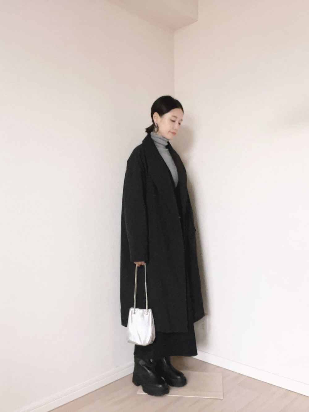 グレー系のニット/セーター、シルバー系のショルダーバッグ、ブラック系のブーツを着用したレディースの冬コーディネートの3枚目の写真