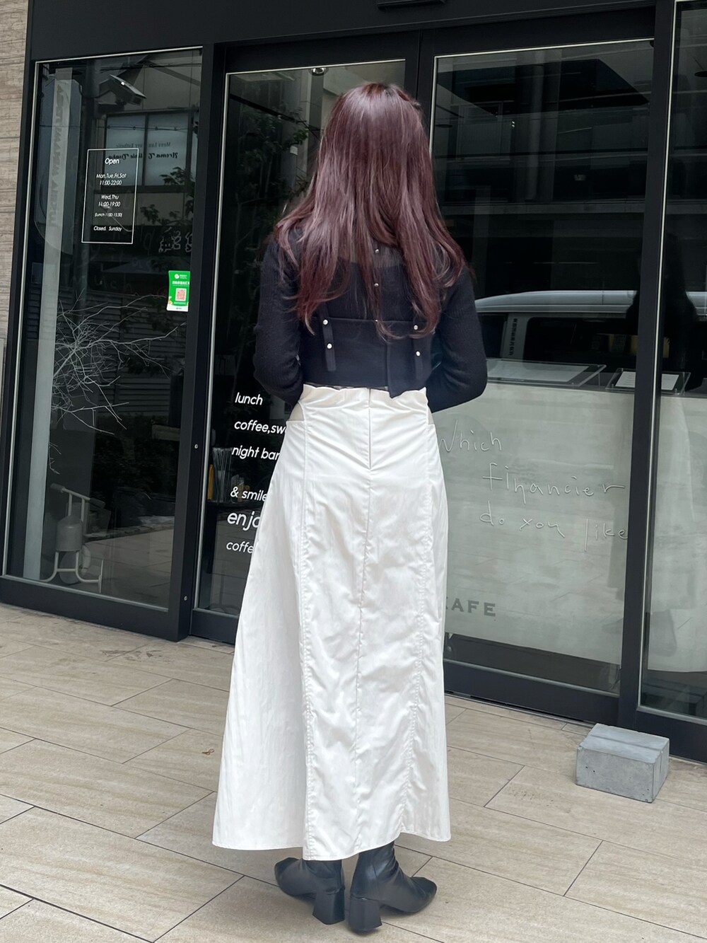 ブラック系のニット/セーター、ベージュ系のスカート、ブラック系のニット/セーターを着用したレディースの冬コーディネートの2枚目の写真