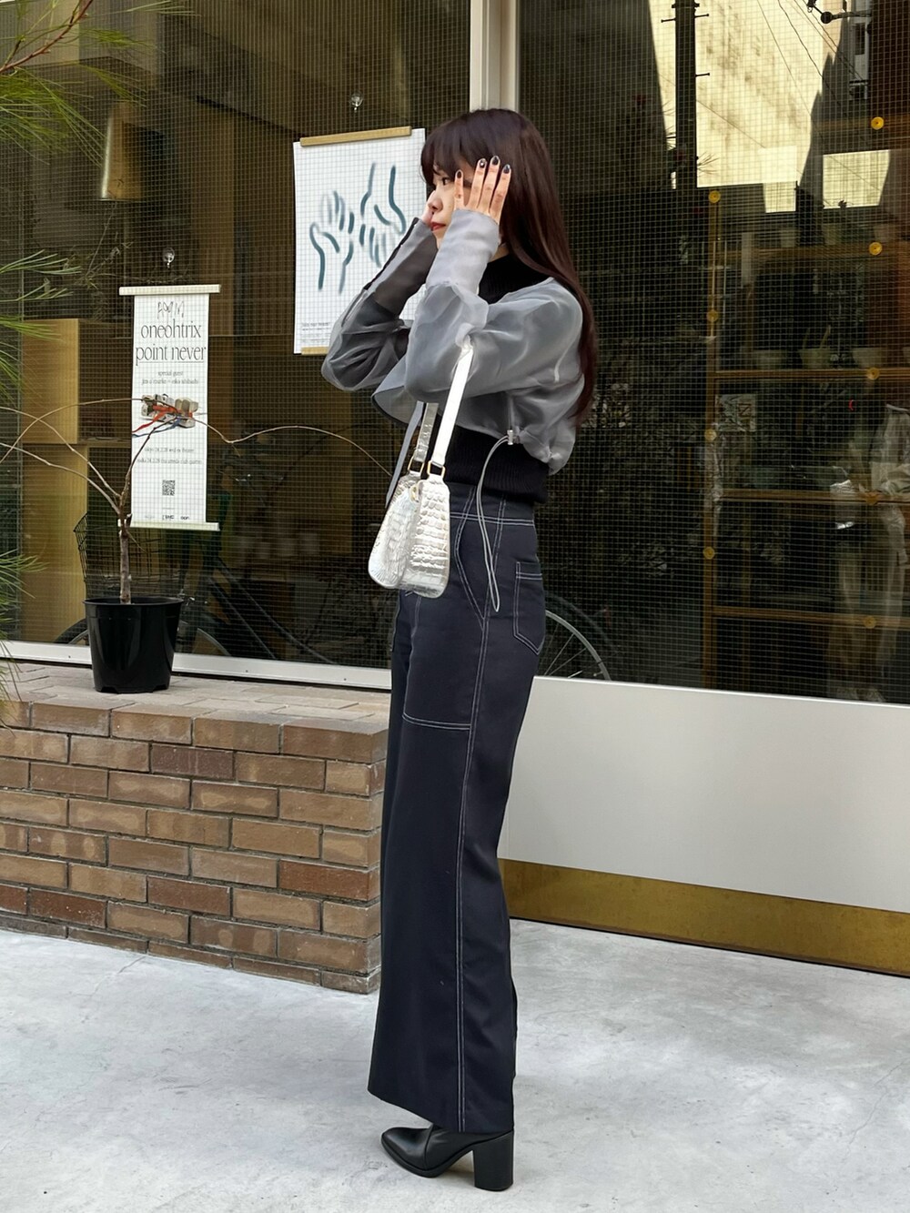 グレー系のノーカラージャケット、ブラック系のニット/セーター、ブルー系のその他パンツを着用したレディースの冬コーディネートの2枚目の写真