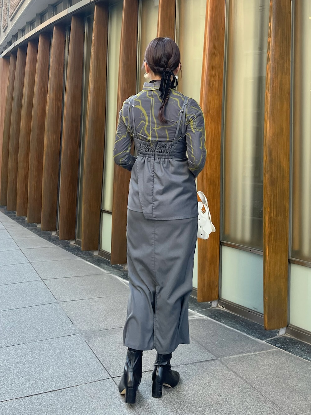 グレー系のワンピース、グレー系のTシャツ/カットソー、ブラック系のニット/セーターを着用したレディースの冬コーディネートの3枚目の写真