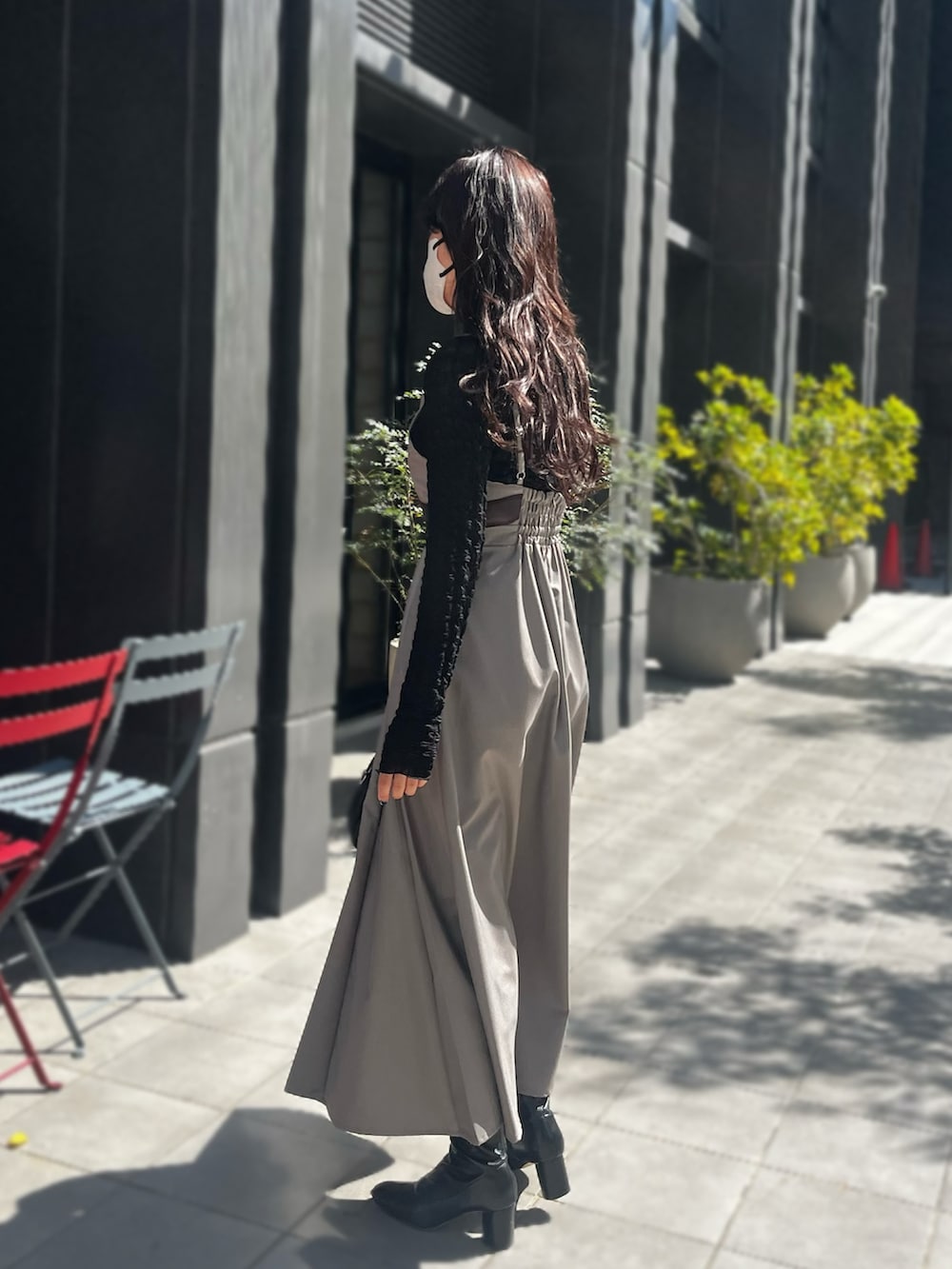 ブラウン系のワンピース、ブラック系のTシャツ/カットソーを着用したレディースの春コーディネートの3枚目の写真