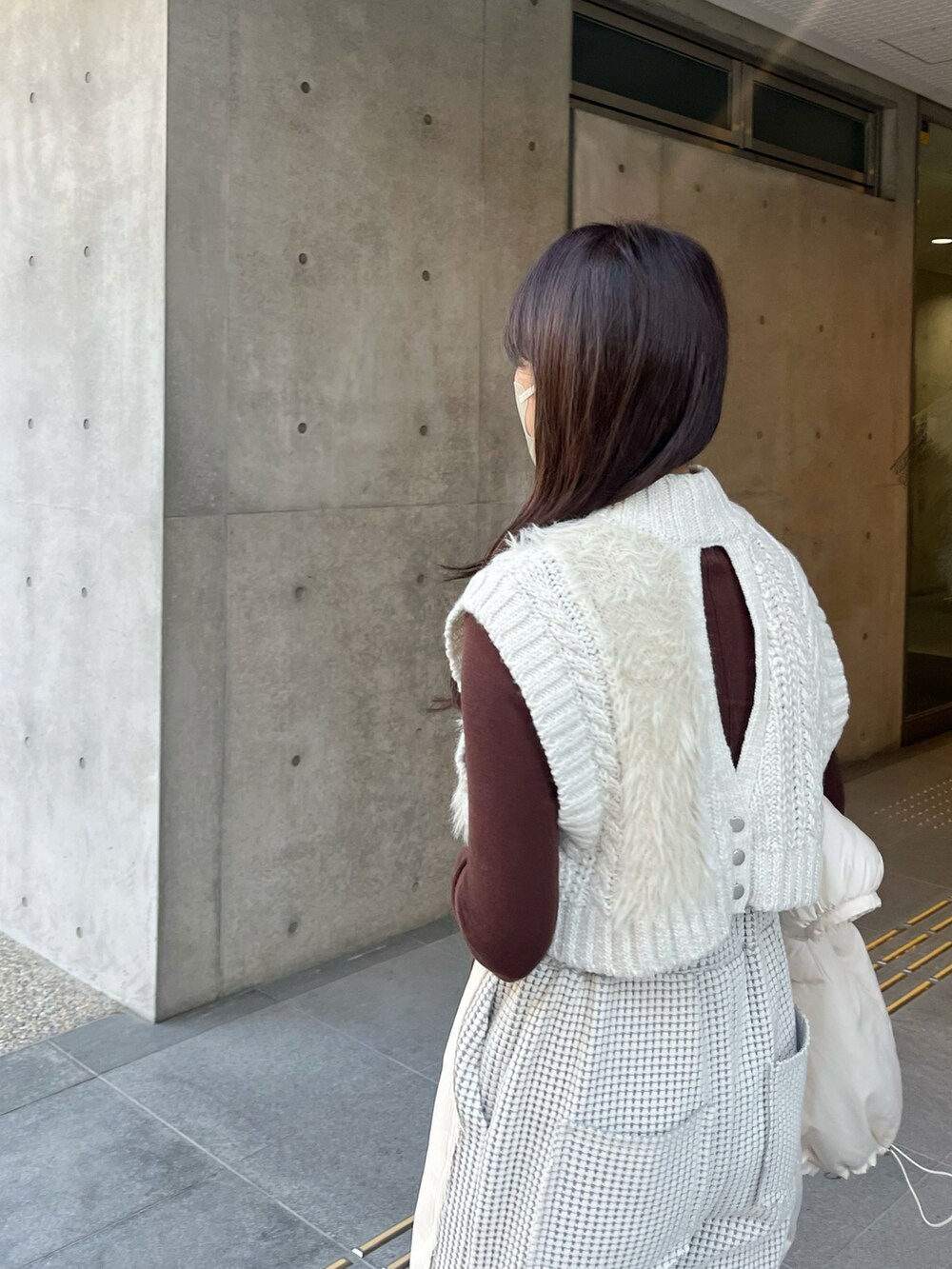 ホワイト系のダウンジャケット/コート、ホワイト系のニット/セーター、ブラウン系のニット/セーターを着用したレディースの冬コーディネートの4枚目の写真