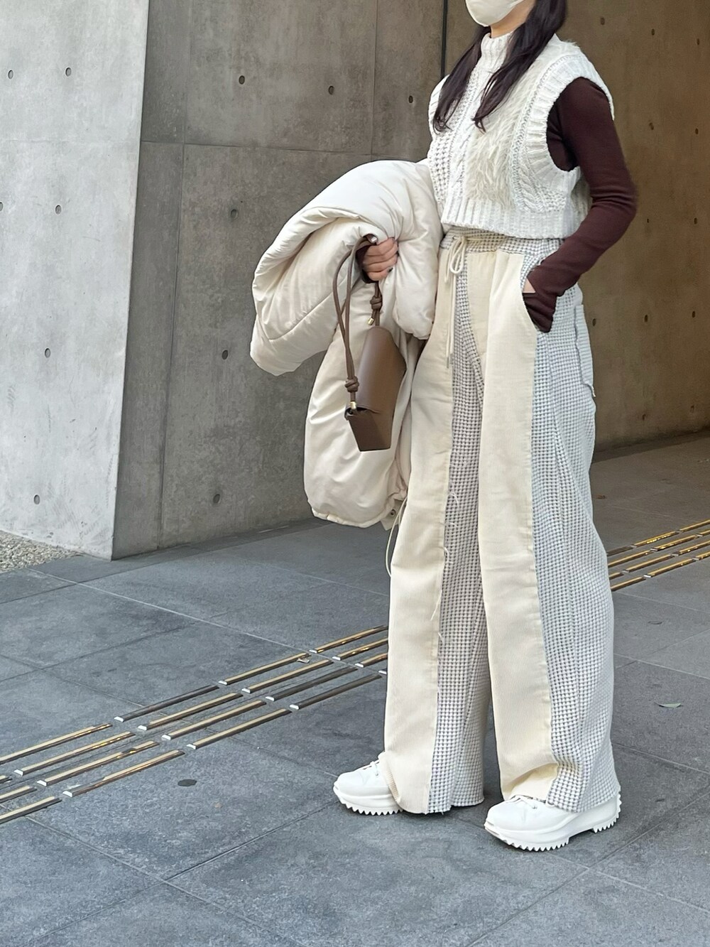 ホワイト系のダウンジャケット/コート、ホワイト系のニット/セーター、ブラウン系のニット/セーターを着用したレディースの冬コーディネートの2枚目の写真