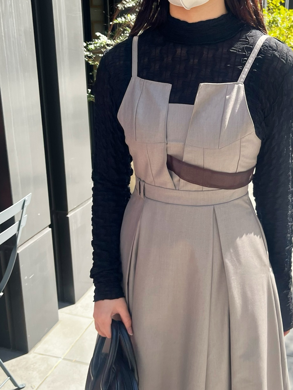 ブラウン系のワンピース、ブラック系のTシャツ/カットソーを着用したレディースの春コーディネートの4枚目の写真