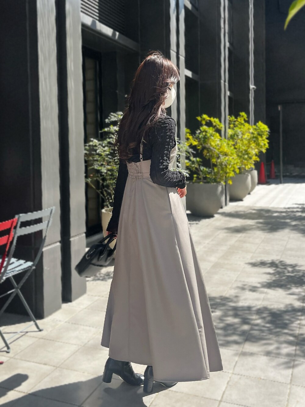 ブラウン系のワンピース、ブラック系のTシャツ/カットソーを着用したレディースの春コーディネートの2枚目の写真