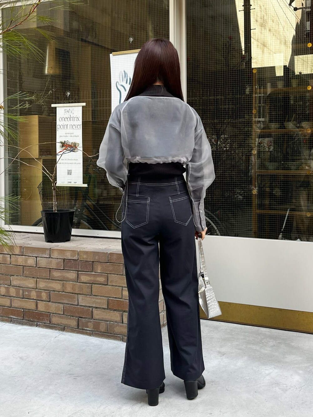グレー系のノーカラージャケット、ブラック系のニット/セーター、ブルー系のその他パンツを着用したレディースの冬コーディネートの3枚目の写真