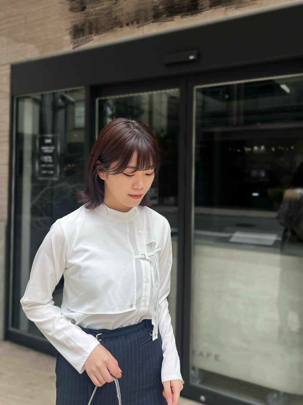 ブラック系のその他シューズ、ホワイト系のシャツ/ブラウス、ブルー系のスカートを着用したレディースの春コーディネートの3枚目の写真