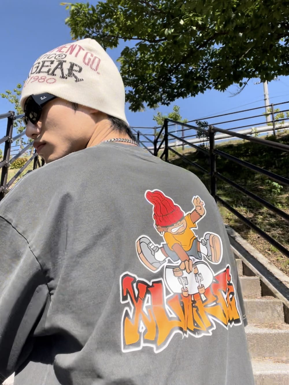 ブラック系のTシャツ/カットソー、グリーン系のカーゴパンツ、ブラック系のスニーカーを着用したメンズの春コーディネートの3枚目の写真