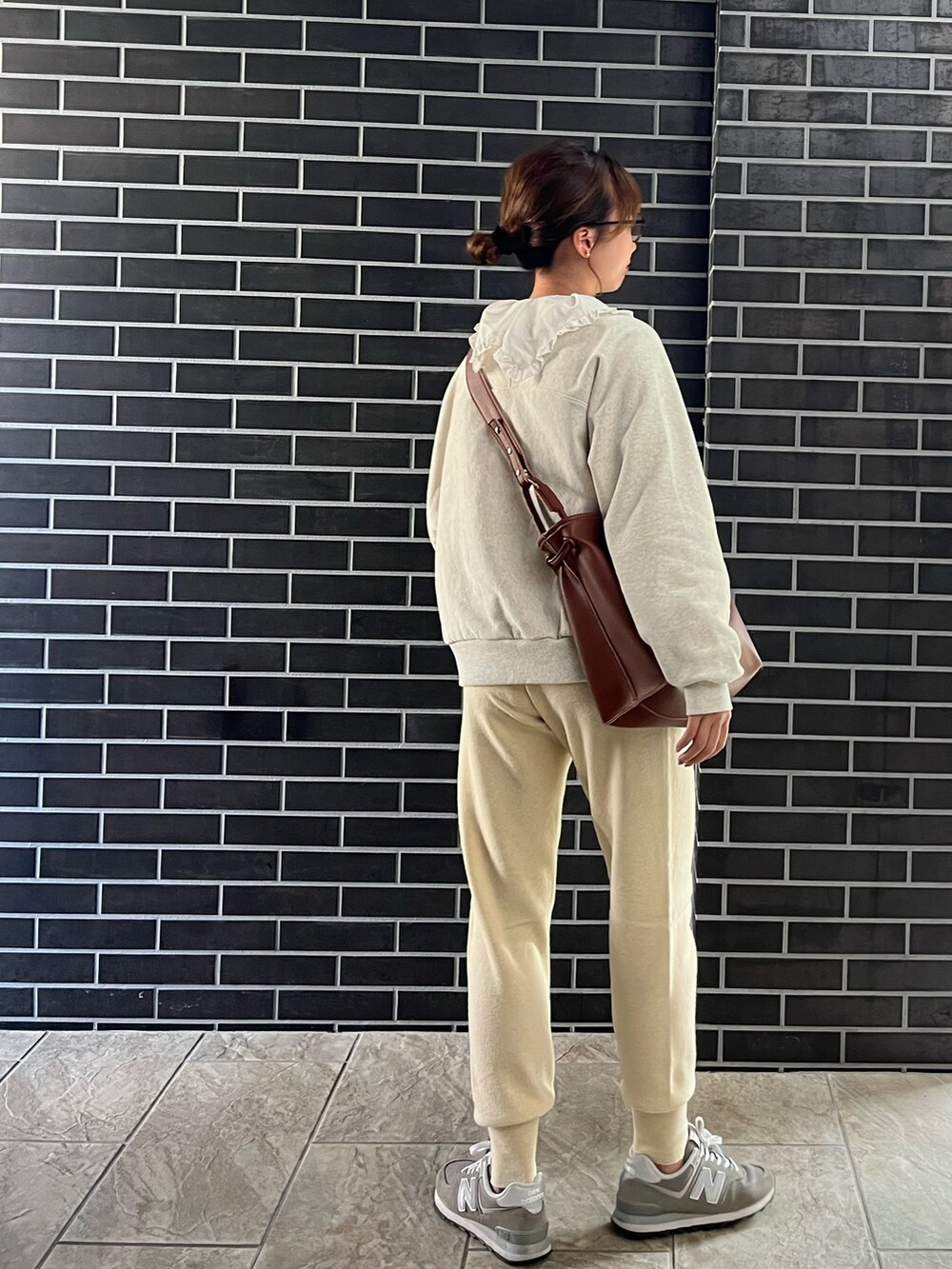 ホワイト系のスウェットパンツ、ブラウン系のトートバッグ、ホワイト系のシャツ/ブラウスを着用したレディースの秋コーディネートの3枚目の写真