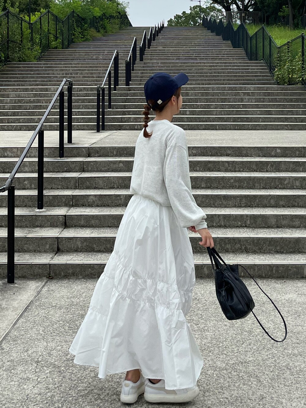 ホワイト系のTシャツ/カットソー、ホワイト系のスカート、ブラック系のトートバッグを着用したレディースの秋コーディネートの2枚目の写真