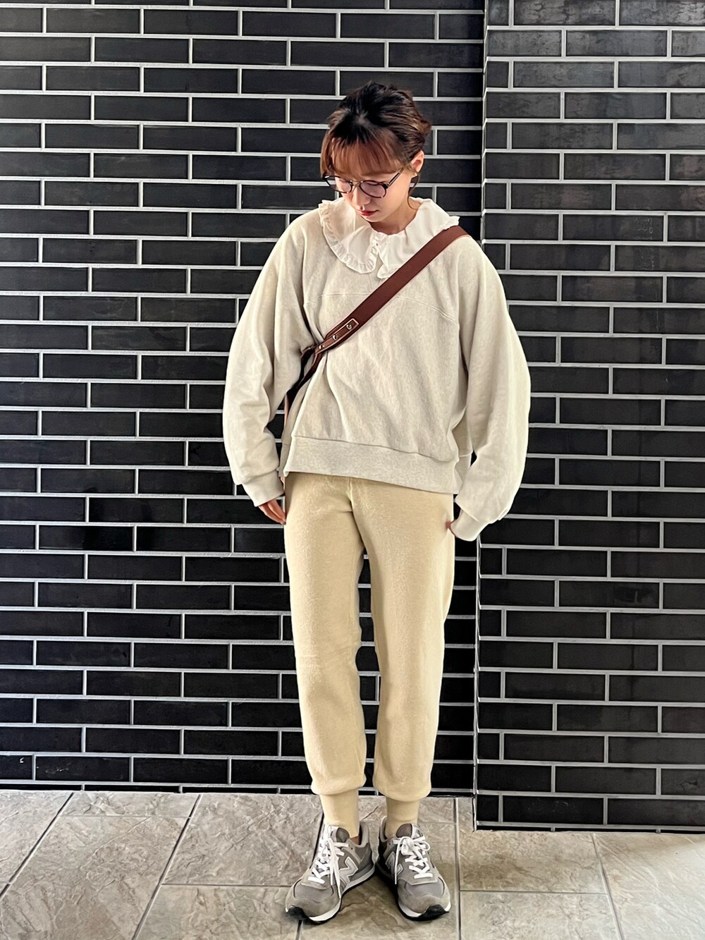 ホワイト系のスウェットパンツ、ブラウン系のトートバッグ、ホワイト系のシャツ/ブラウスを着用したレディースの秋コーディネートの2枚目の写真