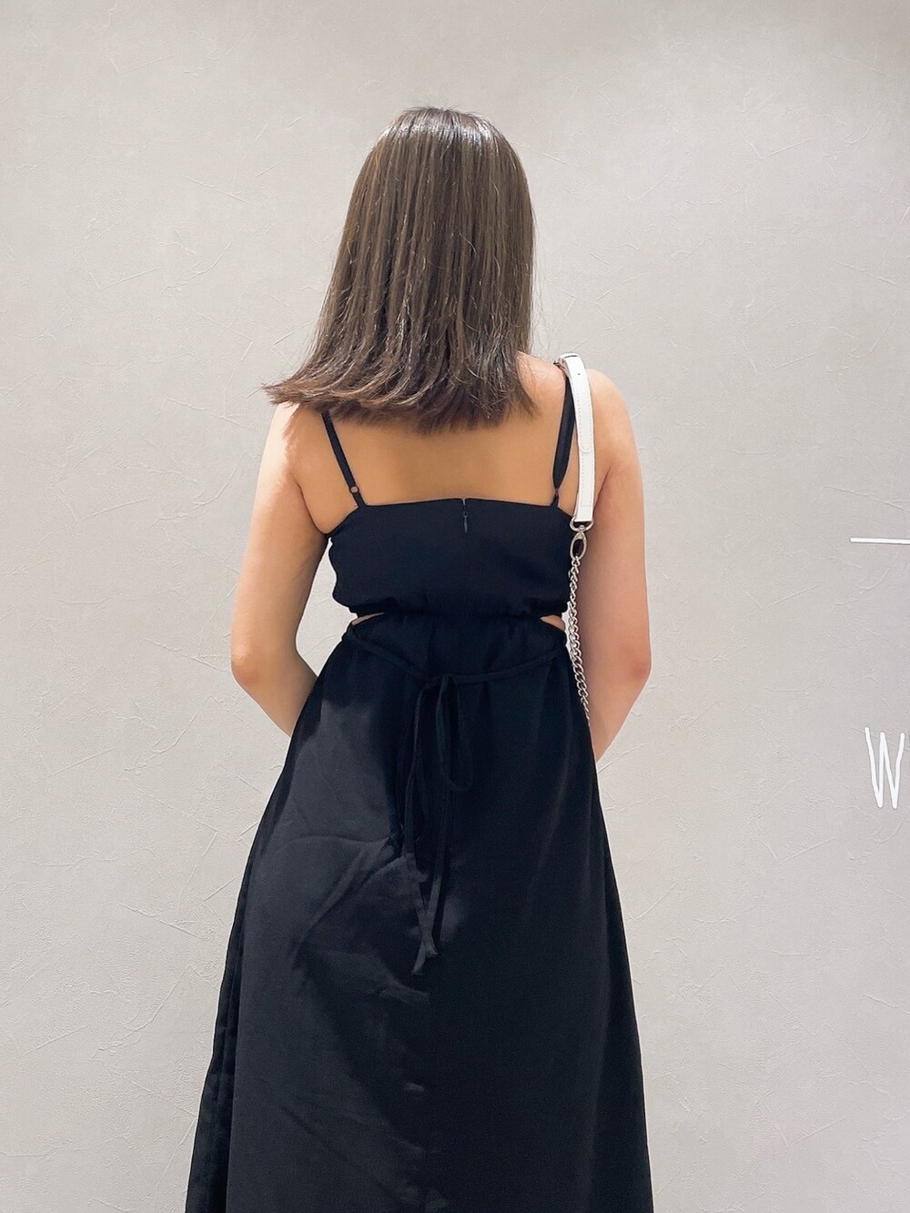 ブラック系のワンピース、ホワイト系のサンダル、ホワイト系のショルダーバッグを着用したレディースの夏コーディネートの7枚目の写真