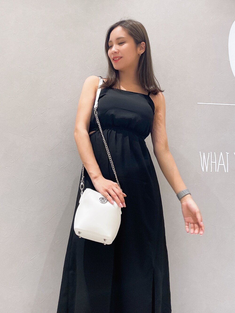 ブラック系のワンピース、ホワイト系のサンダル、ホワイト系のショルダーバッグを着用したレディースの夏コーディネートの5枚目の写真