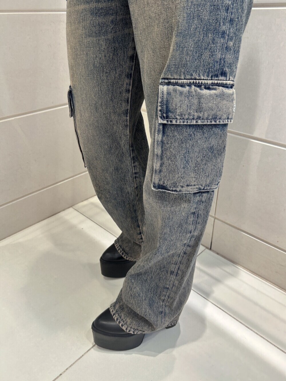 ブルー系のデニムパンツ、ブラック系のブーツ、ブラック系のニット/セーターを着用したレディースの秋コーディネートの8枚目の写真
