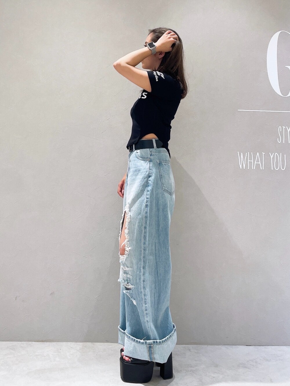 ブラック系のTシャツ/カットソー、ブルー系のデニムパンツ、ブラック系のサンダルを着用したレディースの夏コーディネートの2枚目の写真