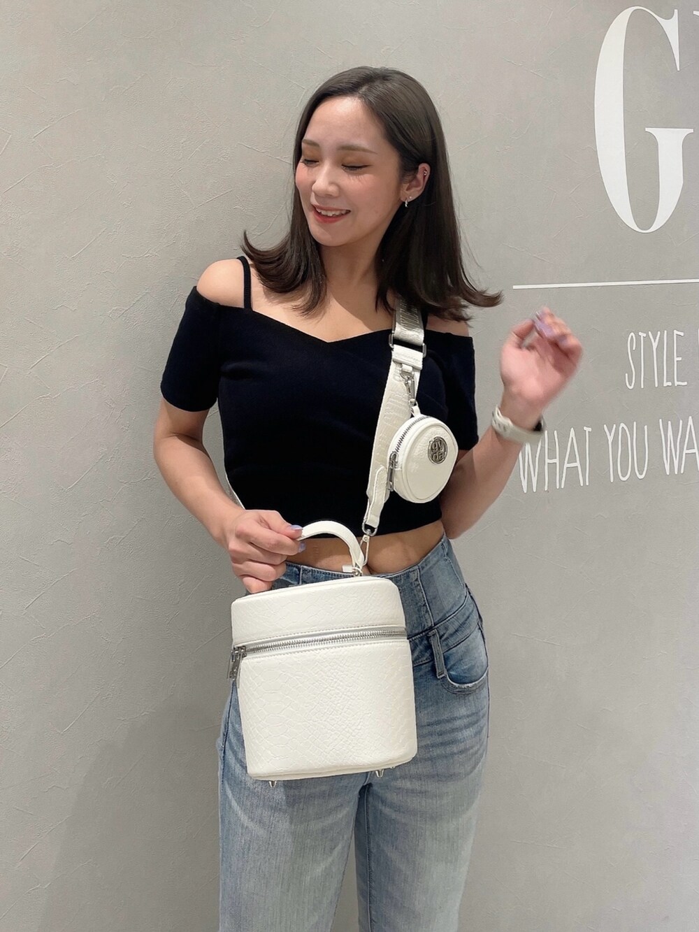 ブラック系のTシャツ/カットソー、ブルー系のデニムパンツ、ホワイト系のハンドバッグを着用したレディースの春コーディネートの4枚目の写真