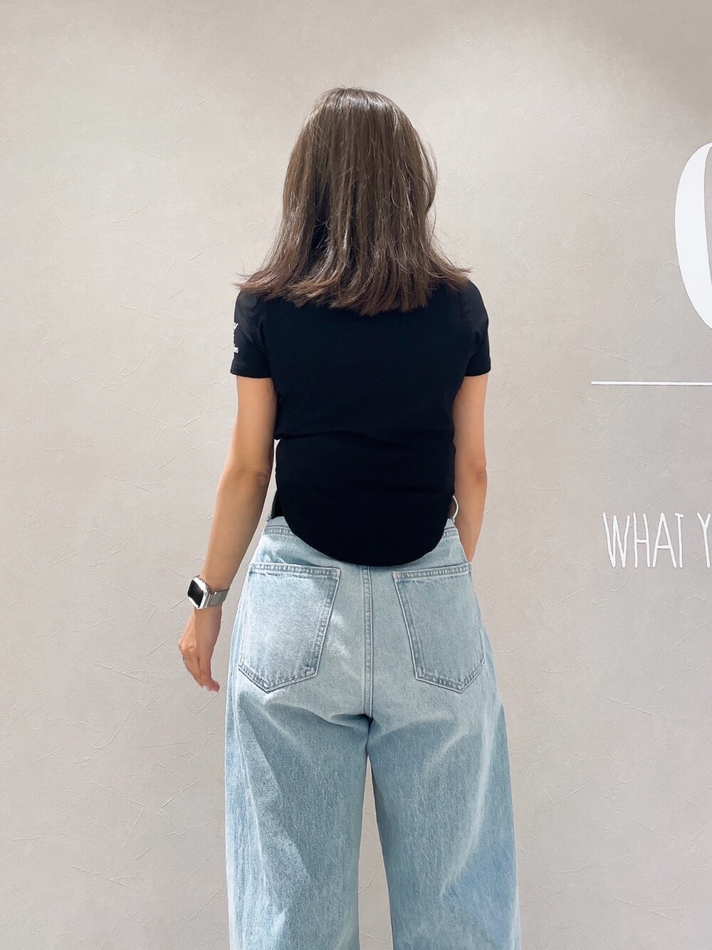 ブラック系のTシャツ/カットソー、ブルー系のデニムパンツ、ブラック系のサンダルを着用したレディースの夏コーディネートの6枚目の写真