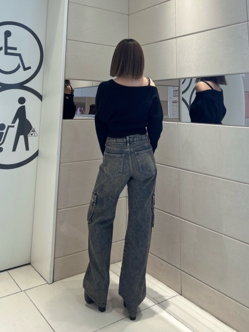 ブルー系のデニムパンツ、ブラック系のブーツ、ブラック系のニット/セーターを着用したレディースの秋コーディネートの3枚目の写真